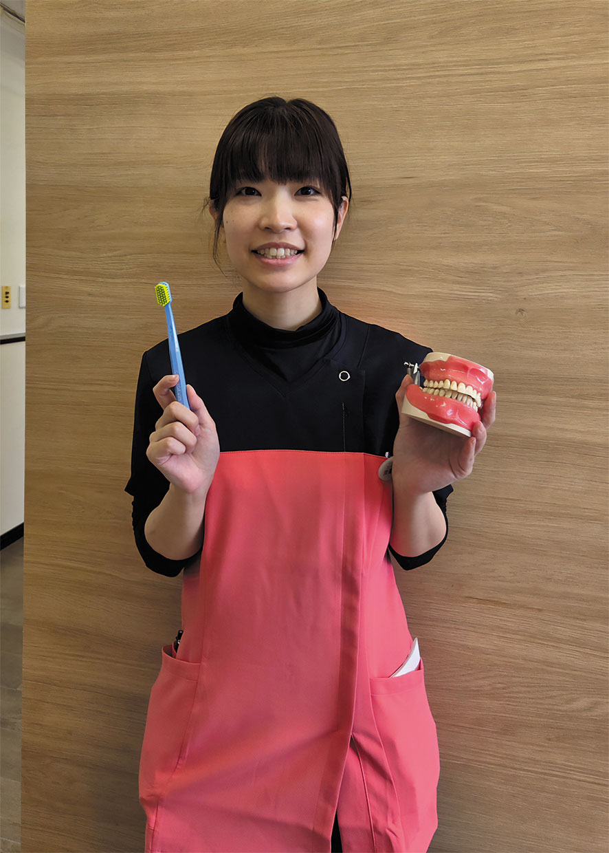 「医療法人川上歯科医院」トリートメントコーディネーター、マネージャーの渡邉 夏実さん。歯ブラシと歯科用模型を持っています。