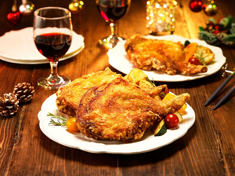 「お肉屋さんのカラアゲ はしづめ」の骨付きモモ肉特大からあげが並ぶクリスマス仕様の食卓。香ばしく揚げられた大ぶりの鶏肉。