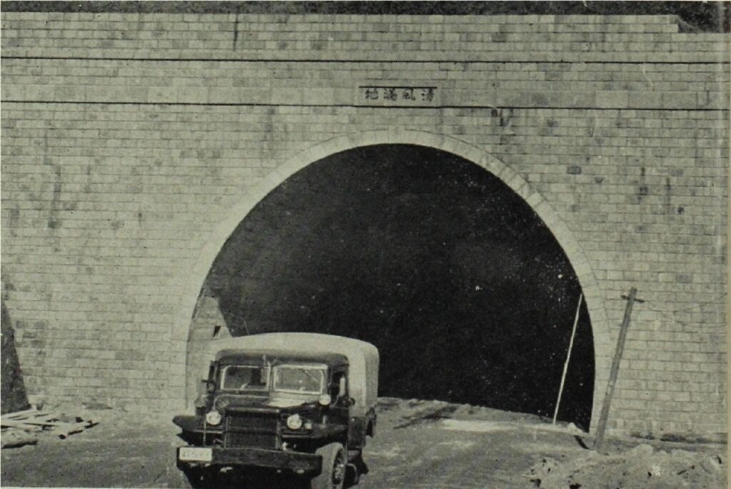 南大分にある大道トンネルの写真(1954年頃)。レンガ造りの半円形アーチ構造のトンネルから、軍用風のトラックが出てくる場面が写されている。トンネル上部には「清風満地」と記された看板が掲げられ、周囲には工事資材や未整備の地面が見られる。地域のインフラ整備や輸送活動の一端を感じさせる、歴史的・実務的な雰囲気を持つ一枚。