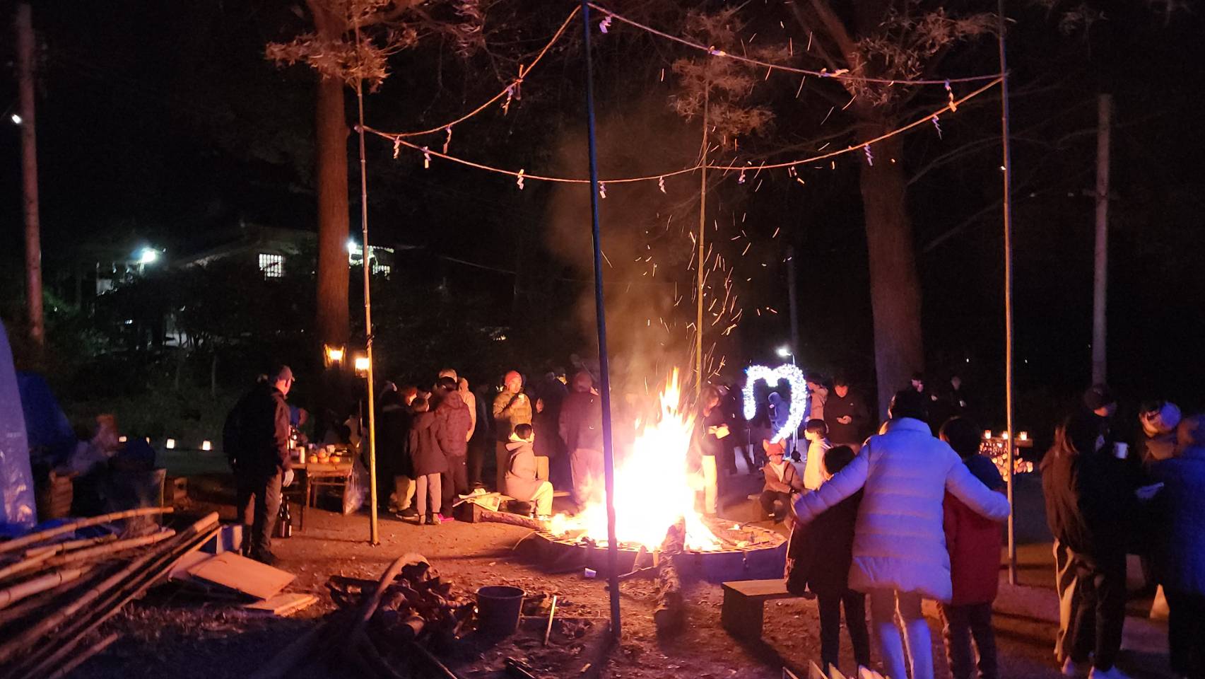 南太平寺・杵築社の竹灯籠まつりと初詣の夜、焚き火を囲む参加者たちの様子