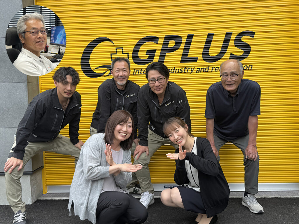黄色いシャッターに「GPLUS」のロゴが大きく描かれた前で、株式会社ジプラスのスタッフ6名が並んで写っている写真。立っている人、しゃがんでいる人が混ざり、全員が笑顔でポーズをとっている。左上にはデスクで作業する人物の小さな丸型写真が重ねて配置され、チームの雰囲気が伝わる構成。